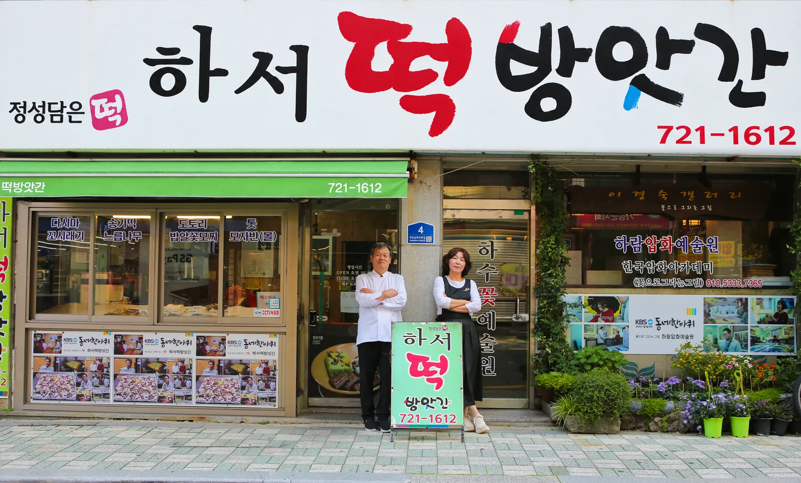 「하서 떡 방앗간」 간판 아래 가게 앞에 선 사장님 부부